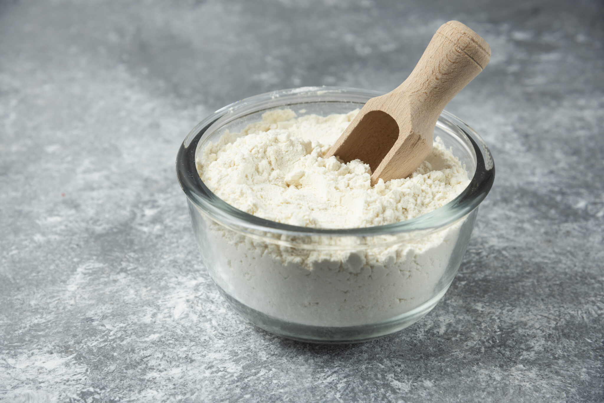Glass bowl of flour on marble background. High quality photo